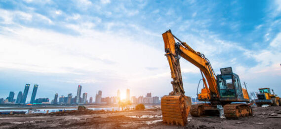 excavator in construction site on sunset sky background